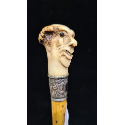 202 - An antique swagger stick, with a fantastic carved horn figural finial. A very unusual and comedic ex... 