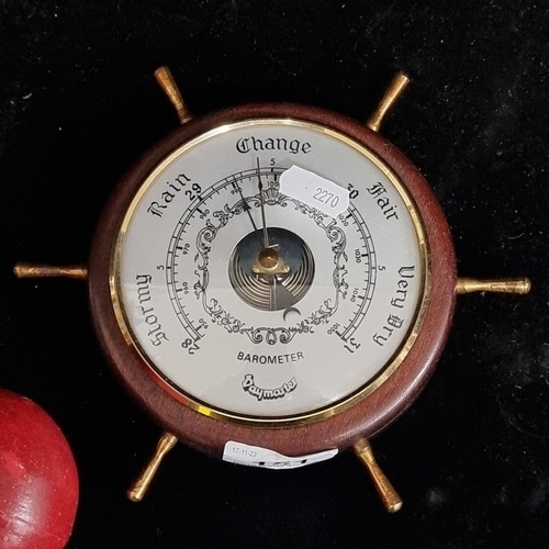 151 - A Daymaster branded ship's wheel barometer. A nice example in good condition with brass detailing. D... 