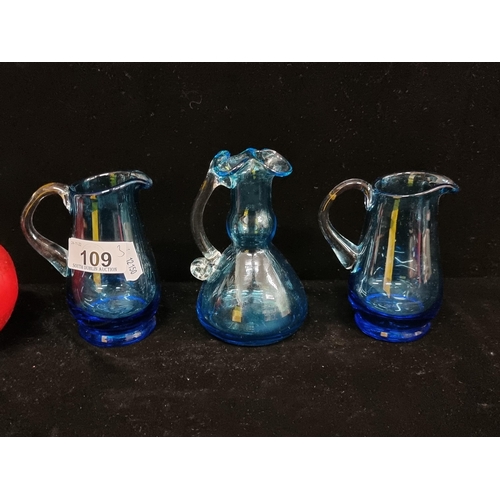 109 - Three 19th century hand blown glassware jugs in a vibrant shade of blue, including an example with d... 