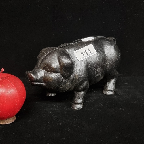 111 - A very heavy, cast metal piggy bank with a charcoal black finish.