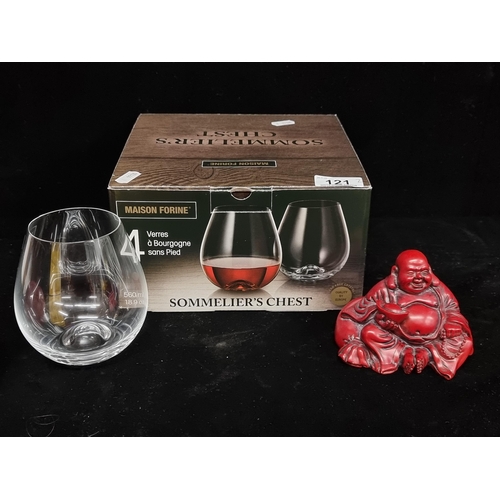 121 - Two items, including a figure of a seated Buddha in a red finish, and a set of four stemless red win... 