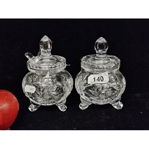 140 - A pretty pair of heavy lidded crystal conserve bowls on three legs, and with deeply cut patterns. In... 