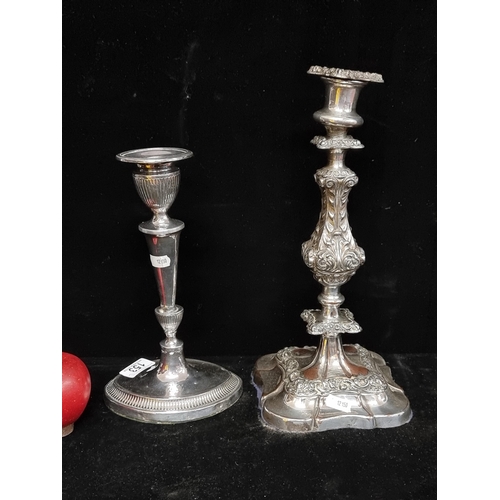 153 - Two ornate EPNS candlesticks, including an example with acanthus leaf motifs and a second gadrooned ... 