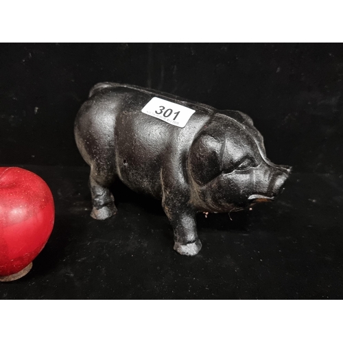 301 - A very heavy, cast metal piggy bank with a charcoal black finish.