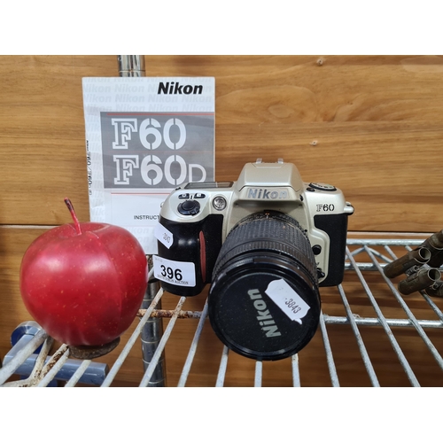 396 - A Nikon analog F60 SLR 35mm film camera. With a 28-80mm lens and a built in flash.Supplied with orig... 