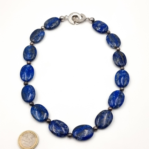 47 - A generous fourteen stone Lapus Lazuli necklace, featuring beautifully hued stones which are cold to... 