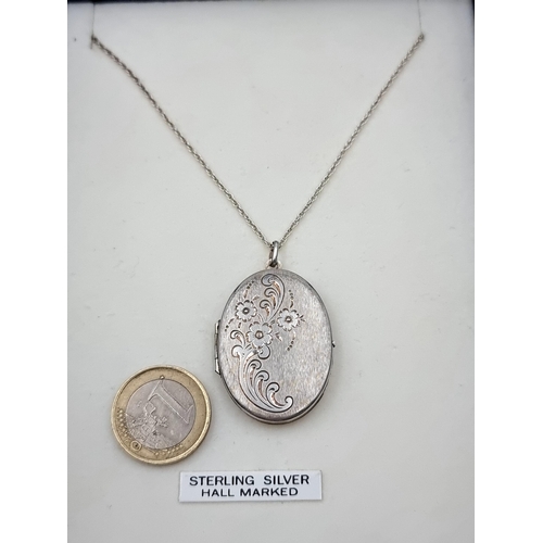 50 - A good quality sterling silver locket pendant, with a pretty floral motif and chain. Length of chain... 