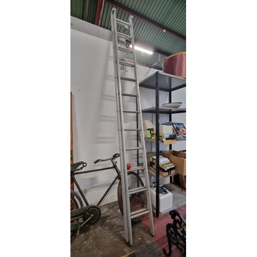 671 - A twelve-step, extendable hinged ladder.