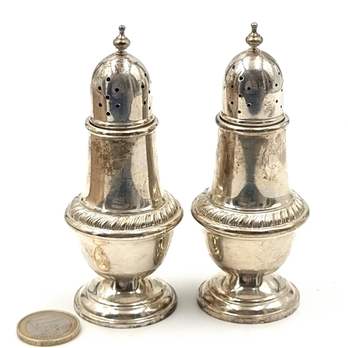 686 - Two sterling silver antique pepperettes, with finial top and graduated base. Height: 10cm. Total wei... 