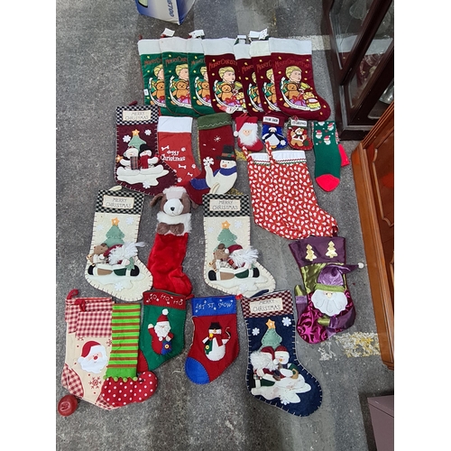 871 - A large collection of 23 christmas stockings of various sizes many including fun motifs of penguins,... 