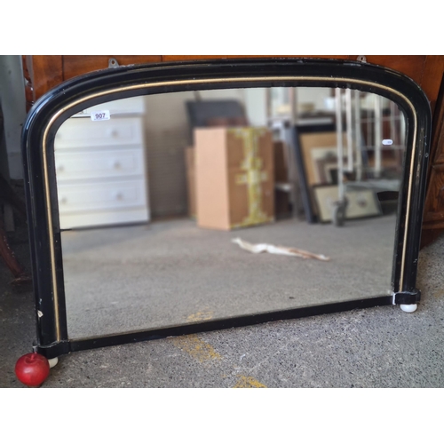 907 - A fab antique  domed, over-mantle mirror. Finished in a glossy black with gilt detail on a bevelled ... 