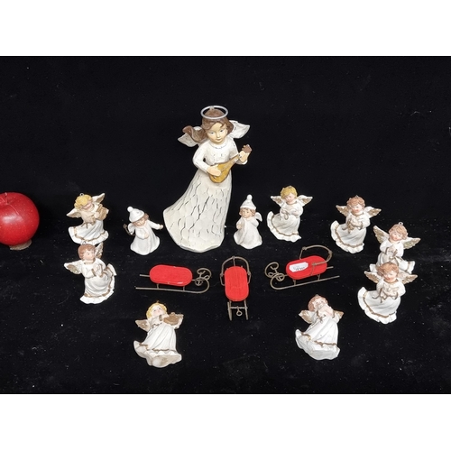 98 - A charming selection of fourteen Christmas decorations, including 3 sleighs and 11 angels in a varie... 