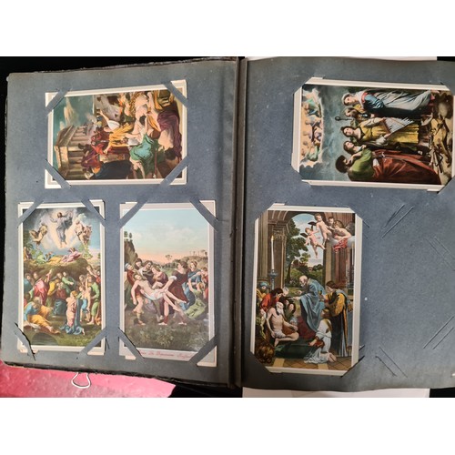 306 - A postcard album housing over 200 antique and vintage postcards and ephemera of religious interest, ... 