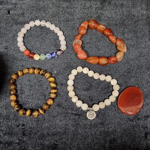 122 - A lovely collection of four natural cold to the touch bracelets. Including tiger eye, Rose quartz  a... 