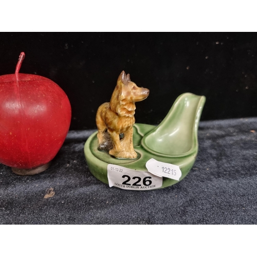 226 - A delightful ceramic pipe holder by Wade of England, featuring a model of an alsatian dog.