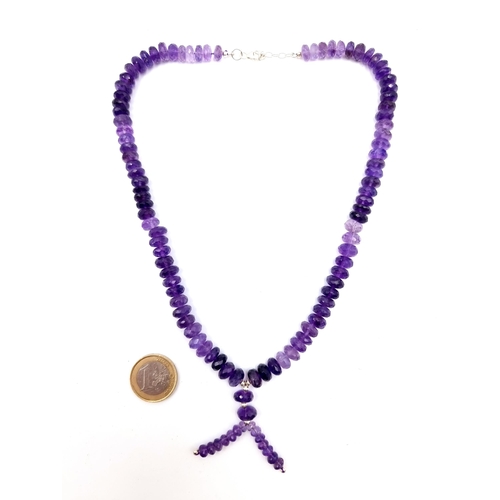 447 - A stunning Amythyst stone single strand graduated necklace, with a pretty tassel accent. This exampl... 