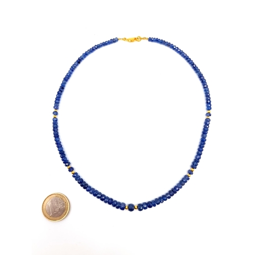 448 - A single strand graduated Blue Sapphire necklace, with gold foil bead accents. Length of necklace: 4... 