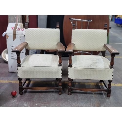 482 - A pair of antique oak heavy quality armchairs, with high arms, turned supports, stud detailing and u... 