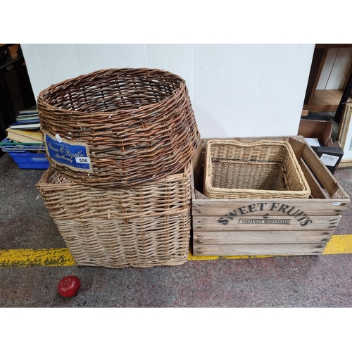 556 - A collection of five baskets including wicker examples and a wooden crate, and a rattan Christmas tr... 