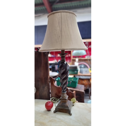 567 - A heavy carved wooden table lamp with an interesting twisted column and a taupe shade.