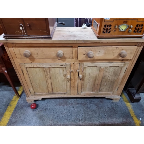 576 - A farmhouse style solid antique pine sideboard with two drawers to top and two cupboards to base wit... 