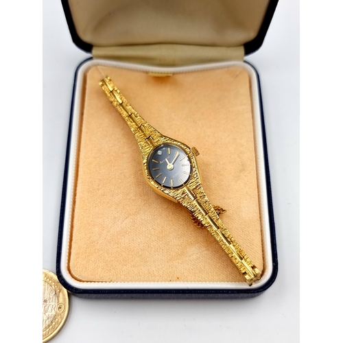 421 - A striking vintage Accurst quartz wristwatch, with a sleek black dial, baton hands, an intricate gol... 