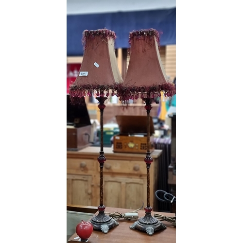 625 - A pair of very tall pretty table lamps, with a marbled stem, richly coloured bead detail and feather... 