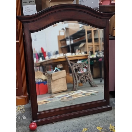 640 - A large, elegant over-mantle mirror. With bevelled glass and an arched wooden frame. H109cm x W94cm