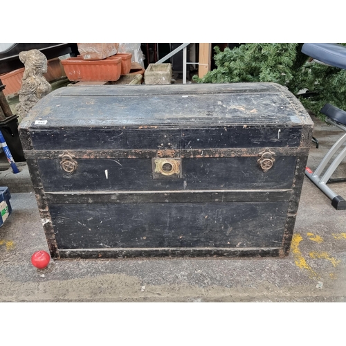 642 - A huge antique travel chest with domed top, metal reinforcements, leather handles and brass clasp. A... 