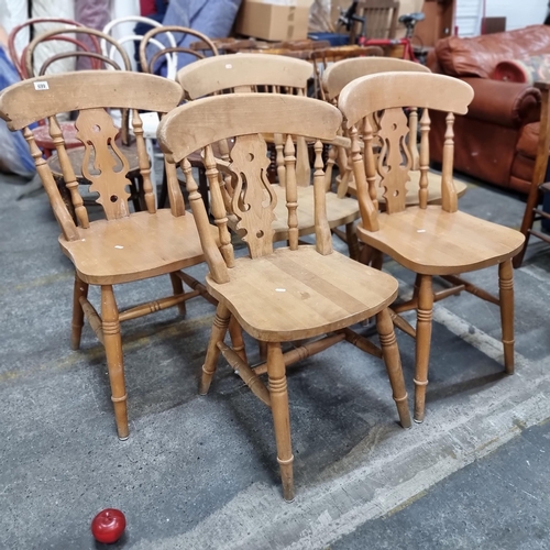 699 - A set of five country kitchen style chairs in a beechwood. With a lyre-back detail. Includes one arm... 