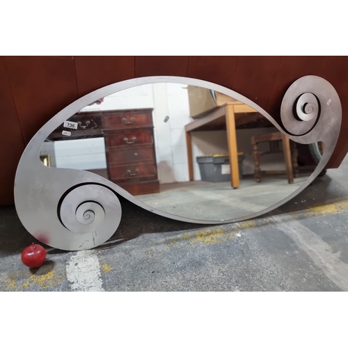 736 - A fantastic large wall mirror on a decorative metal base of curvilinear spirals, perfect as a statem... 