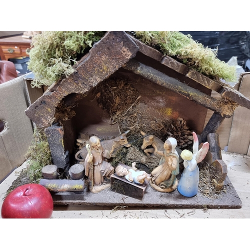 746 - A festive vintage nativity crib including Mary, Joseph, baby Jesus and an angel and barnyard animals... 