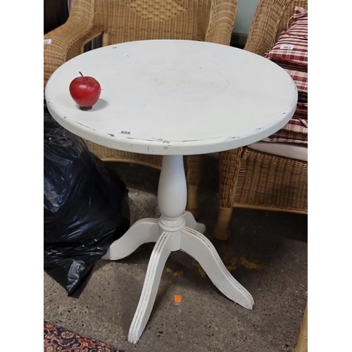 858 - A shabby chic style round side table on a quadruped base in a white finish.