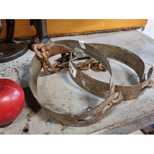 874 - A pair of original antique metal cuffs/shackles with adjustable size, connected by a chain.