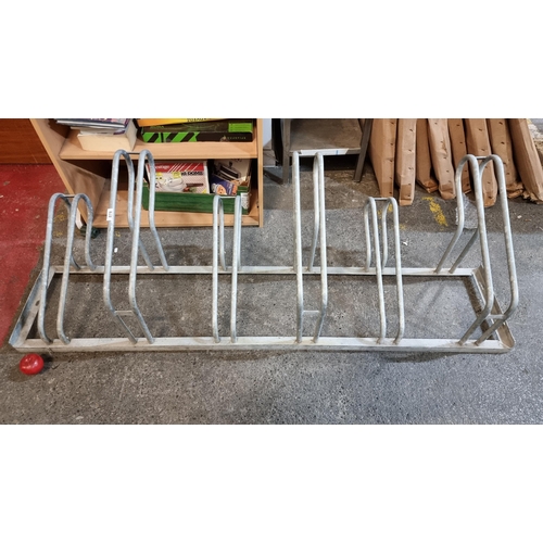 878 - A heavy quality metal bicycle rack with spaces for six bicycles. L182cm