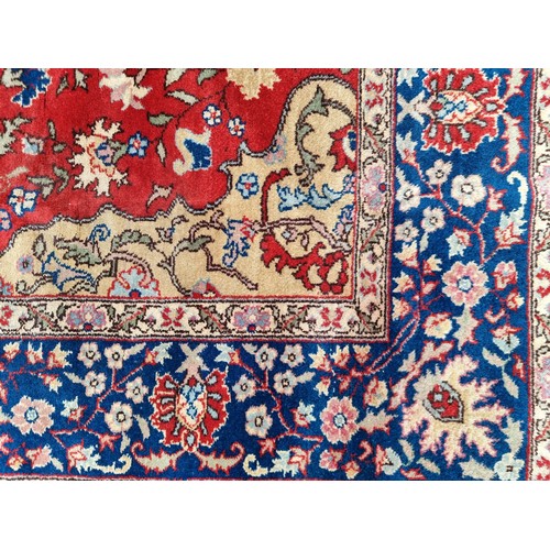 707 - A stunning Persian and knotted rug in patterns of red, cream and blue made in Tabriz, Iran. Mm: 300 ... 