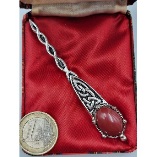 206 - A nicely designed kilt pin from Jacobite Jewellery of Edinburgh. Set with a dark pink gem and featur... 