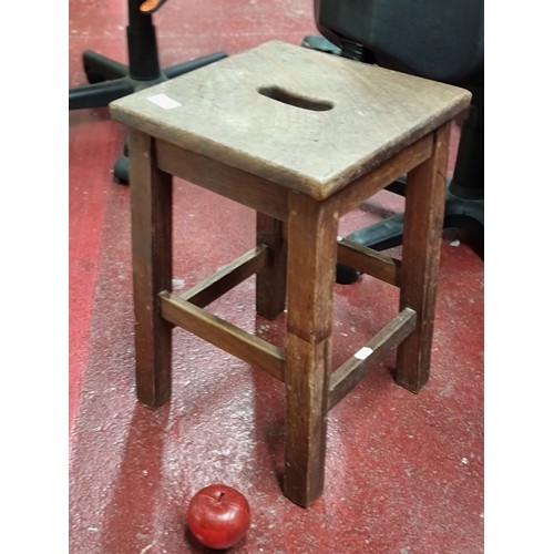 854 - A nice solid wood vintage stool with handle to centre.