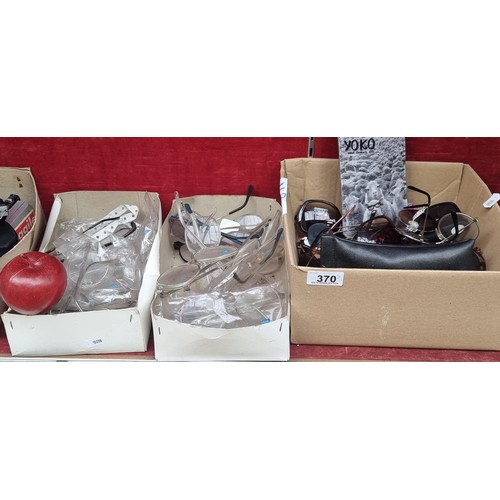 370 - Three boxes of eye glasses including a box of sunglasses and two boxes of reading lenses with a vari... 