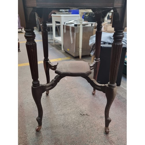 539 - A very elegant two tier table with curved edges and delicate string inlay, on four ceramic castors.