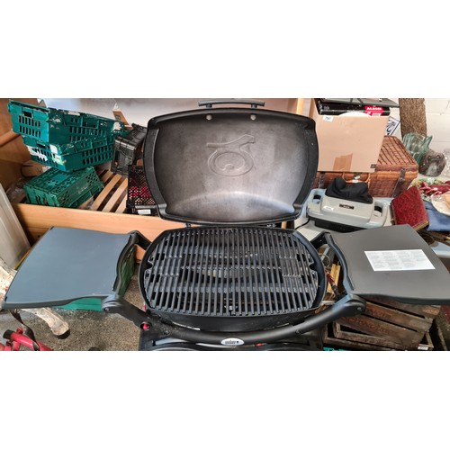 795 - An as new Weber branded barbeque (BBQ) grill. Model Q2000. With integrated stand and Calor Gas bottl... 