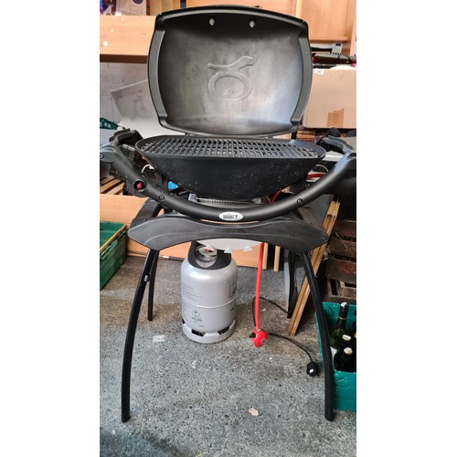 795 - An as new Weber branded barbeque (BBQ) grill. Model Q2000. With integrated stand and Calor Gas bottl... 