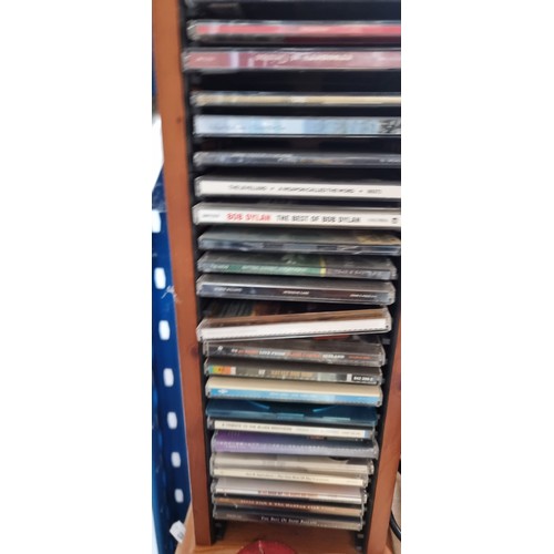 816 - A wooden tower CD rack including a collection of CDs and DVDs, Lots of U2 in this lot. Also included... 