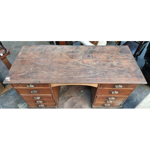 831 - An antique, 19th century ships desk. A large example with ten drawers featuring unusual cast metal c... 