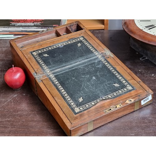 886 - A lovely antique writing slope with brass details, black leather top and small compartments for plen... 