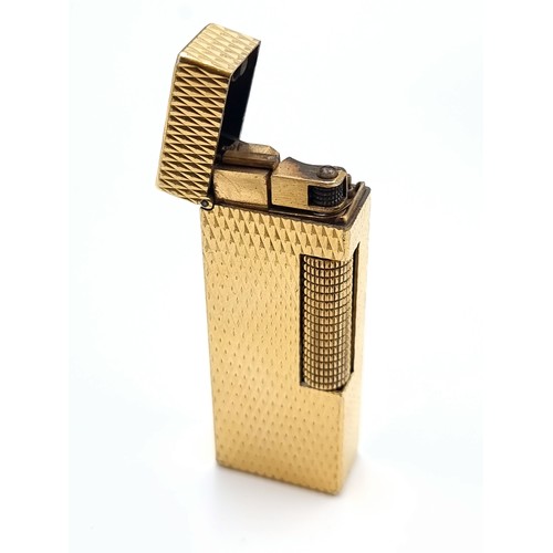 46 - A Dunhill Rollagas lighter, featuring a nicely detailed gold machine cut finish. Comes in original p... 