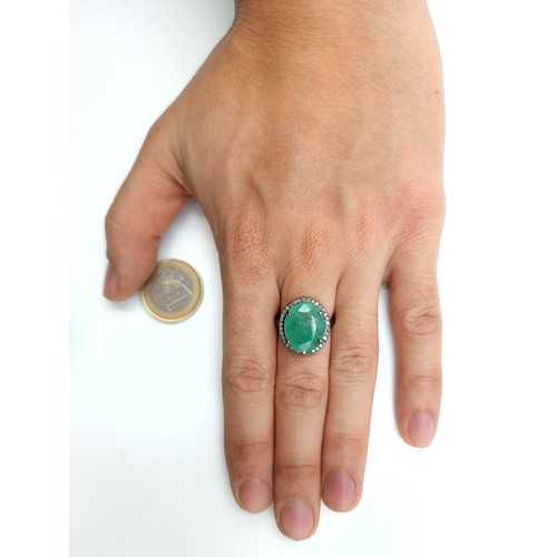 446 - A beautiful oval cut Emerald and Diamond ring, of a centre stone 6.7 carats and a halo surround of .... 