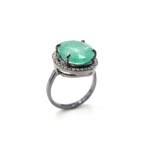 446 - A beautiful oval cut Emerald and Diamond ring, of a centre stone 6.7 carats and a halo surround of .... 