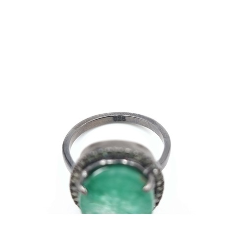 446 - A beautiful oval cut Emerald and Diamond ring, of a centre stone 6.7 carats and a halo surround of .... 