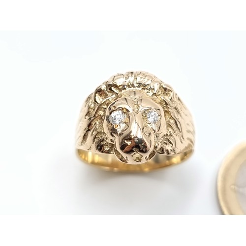 670 - An unusual 9 carat gold gentleman's lion head ring, set with White Sapphire stone eyes and mounted w... 